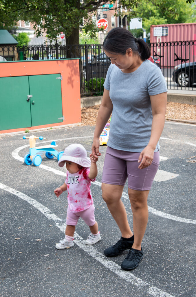 An educator walking with a small child. 