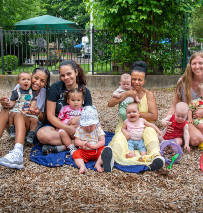 A group of educators and children sitting together at the playground