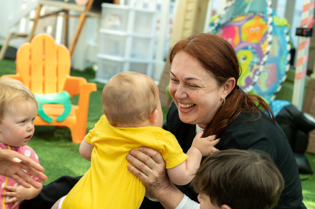 An educator holding a young child.