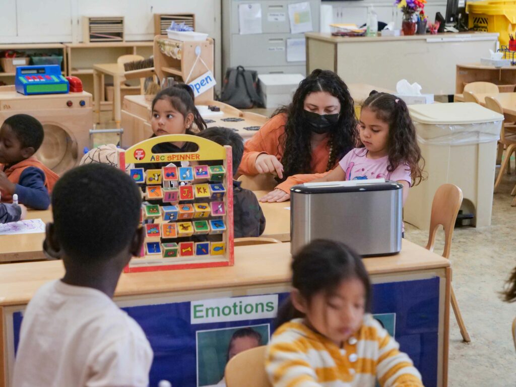 An educator working with children in the classroom.